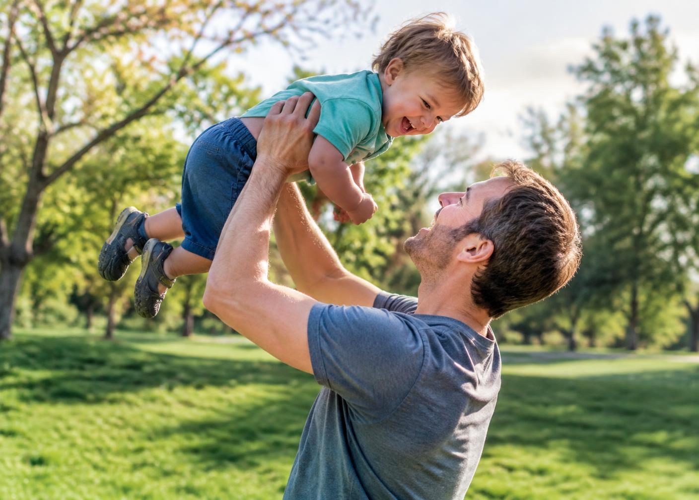 Father lifting his laughing child in a park